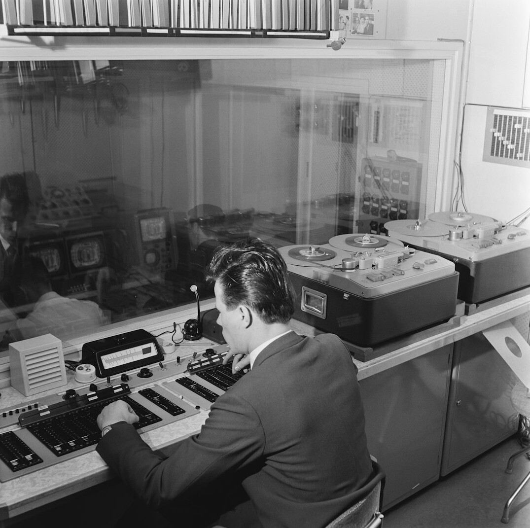 Broadcast control room with technicians monitoring live video feeds on multiple screens