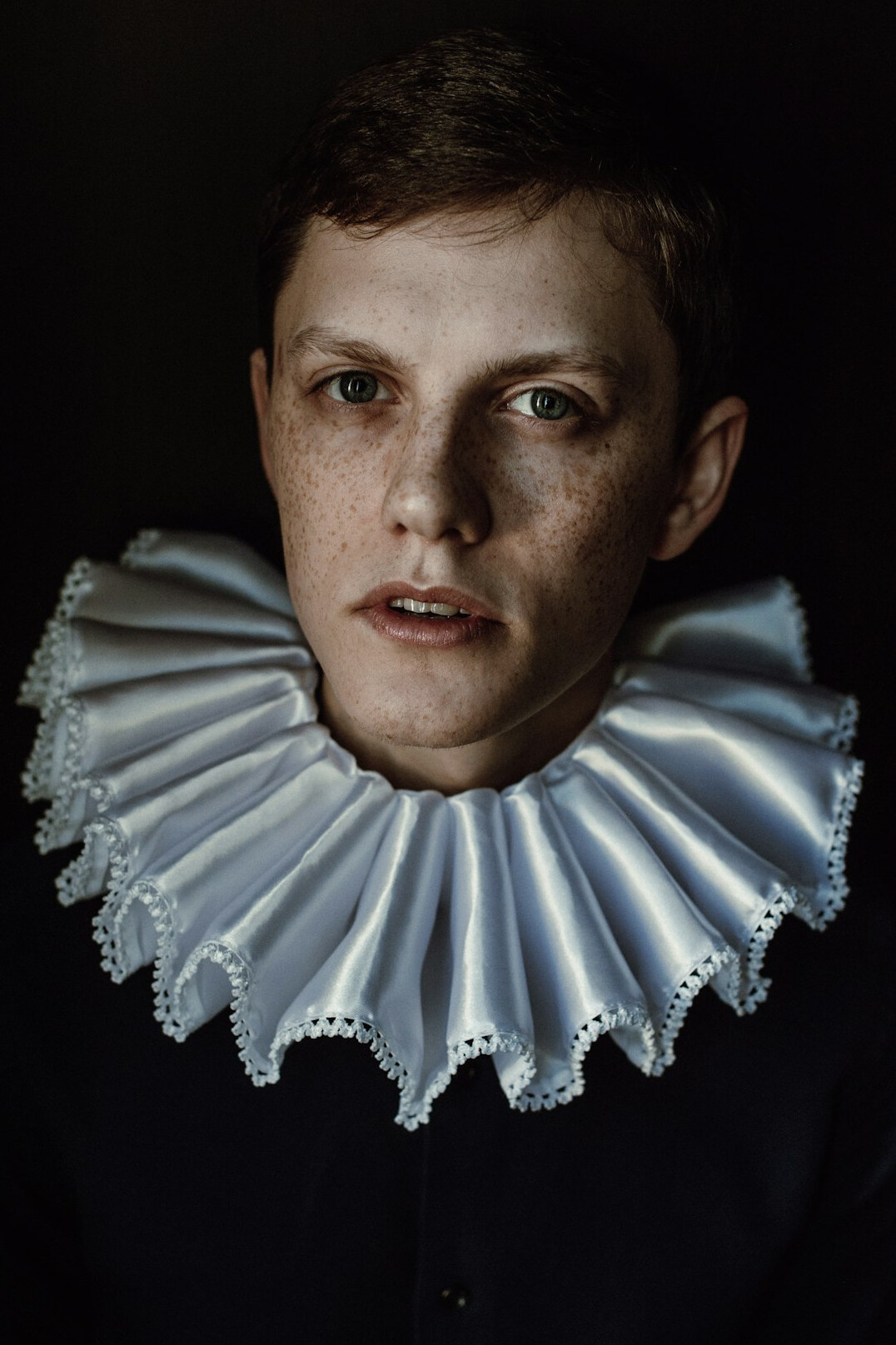 Studio portrait of a man with short hair wearing a collared shirt
